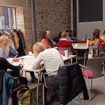People sitting around tables at a Health and Climate Skills Lab.